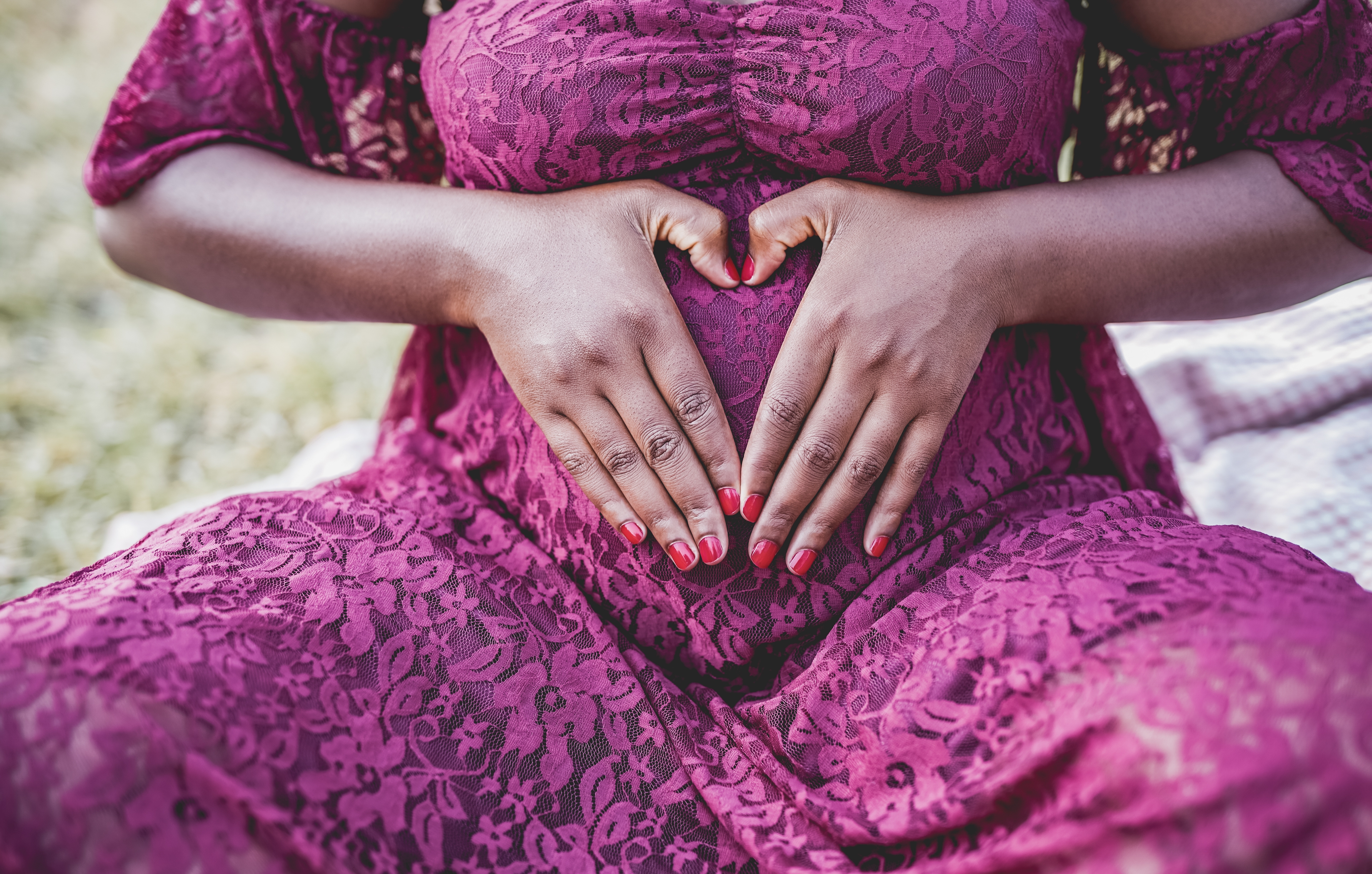 African,Pregnant,Woman,Holding,Hands,In,Front,Of,Belly